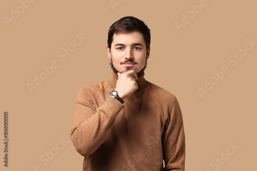 Portrait of thoughtful bearded man on beige background