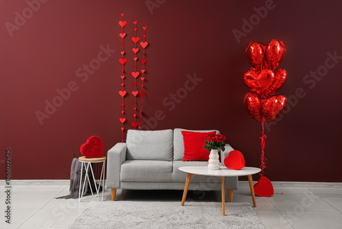 Interior of living room decorated for Valentine's Day with sofa, tables and balloons