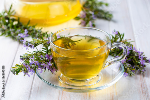 Φωτογραφία Cup of healthy rosemary tea with fresh rosemary bunch on rustic background, wint