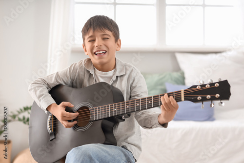 Cute boy playing guitar in ...