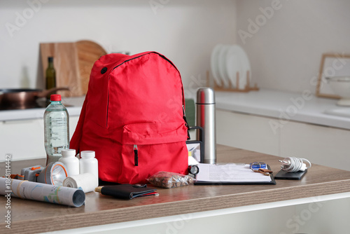 Tableau sur toile Emergency backpack with necessities on table in kitchen