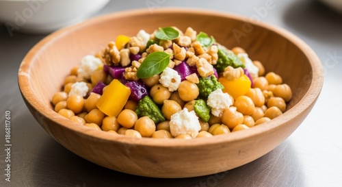 Healthy Chickpea Salad with Colorful Vegetables and Nuts in Wooden Bowl