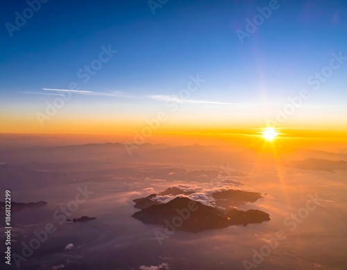 Aerial view of a sunrise over mountains, hazy atmosphere