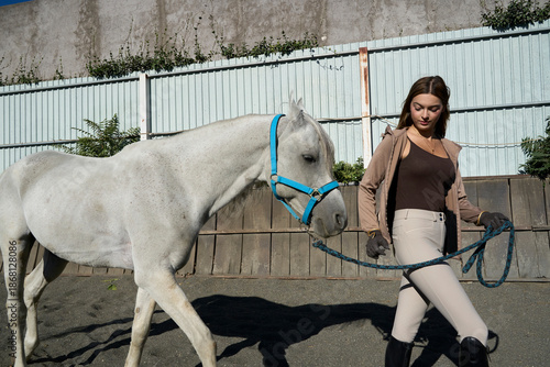 Woman guiding a horse outdoors with focus and coordination
