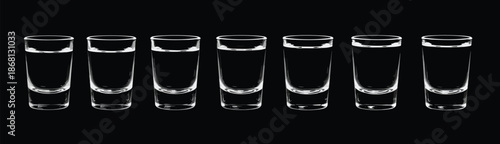 Row of seven clear glass shot glasses filled with clear liquid on black background
