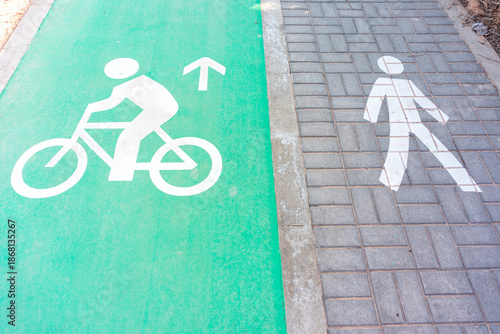 Cyclist and pedestrian icons on a green bike lane and gray sidewalk crosswalk for urban mobility