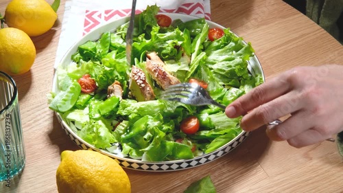 mixing chicken salat with knife and fork in bowl