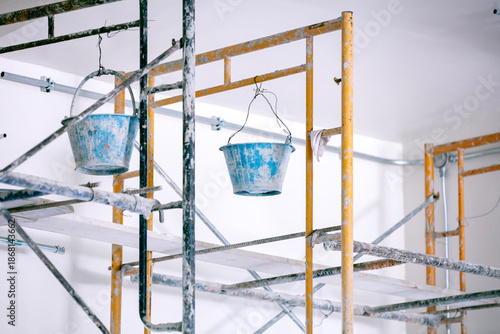 Construction Site Scenery: A study in progress, highlighting the raw essence of construction with metal scaffolding and weathered buckets suspended, set against a backdrop of the space.