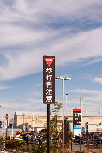 ショッピングモール駐車場の出口付近に設置された止まれと歩行者注意のオリジナルデザイン標識
