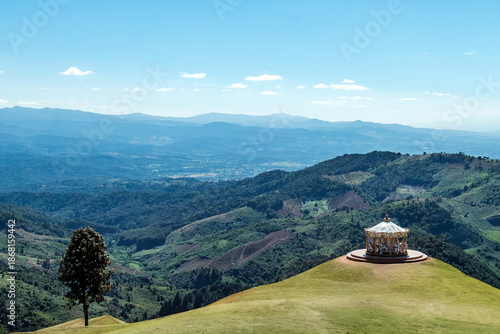 a top of the mountain hill view with small carousal roundabout on their cliff