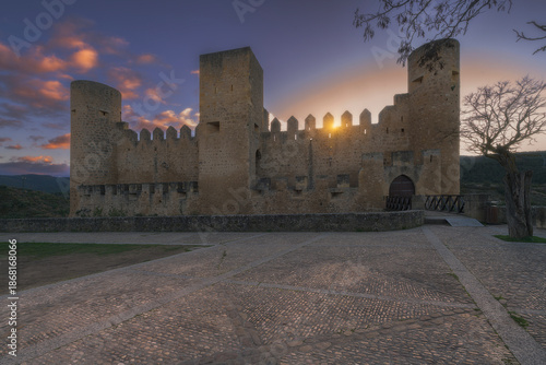 Medieval castle of Frias at sunset with sun star behind battlements in Burgos Spain