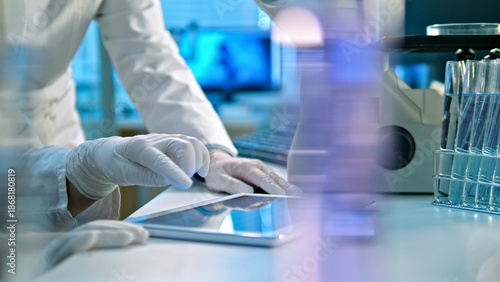 A scientist in a lab coat and gloves examines a document, surrounded by advanced lab equipment, highlighting precision and innovation in a high-tech research setting.