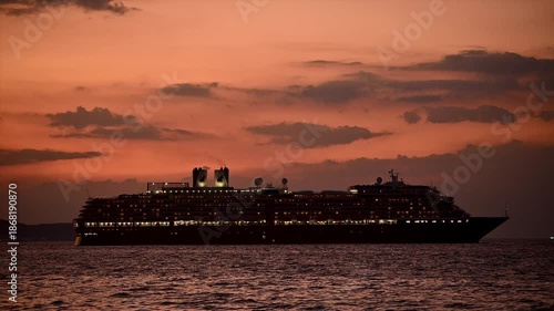 Aerial drone view of a large cruise ship sailing across calm blue ocean waters under clear sky vessel moves steadily through the sea symbolizing luxury travel  tourism maritime transportation and ocea