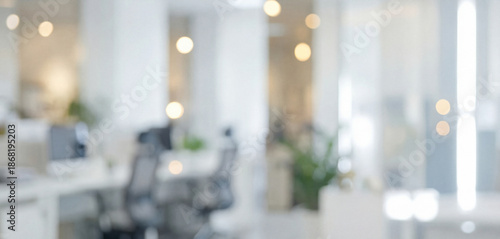 Modern office environment featuring blurred backgrounds. Bright lighting, contemporary furniture, and natural elements create an inviting workspace atmosphere.