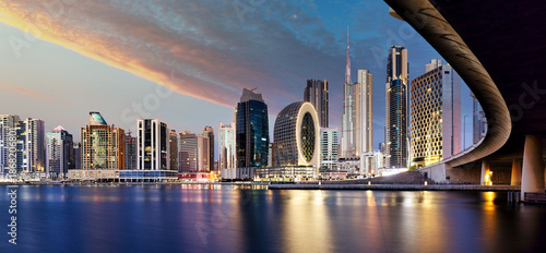 Fotografía Panorama of Dubai skyline from canal Creek at sunrise and night, UAE