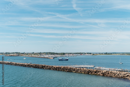 Elevated view of Varberg harbor entrance with breakwater, distant Getterön island and a ship, Sweden