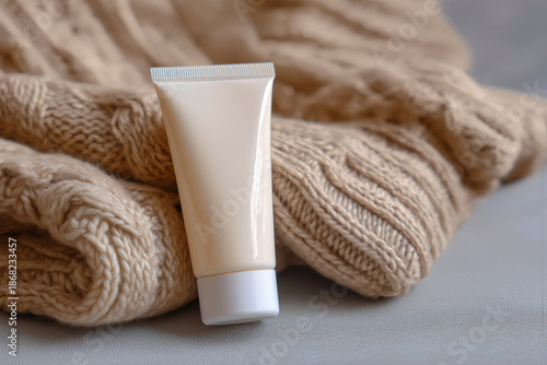 Unbranded cosmetic product tube on knitted beige sweater
