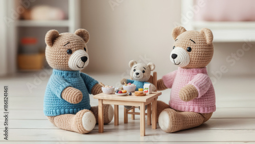 Two cute knitted teddy bears having tea with a smaller bear at a table. Family life, care and support concept.  