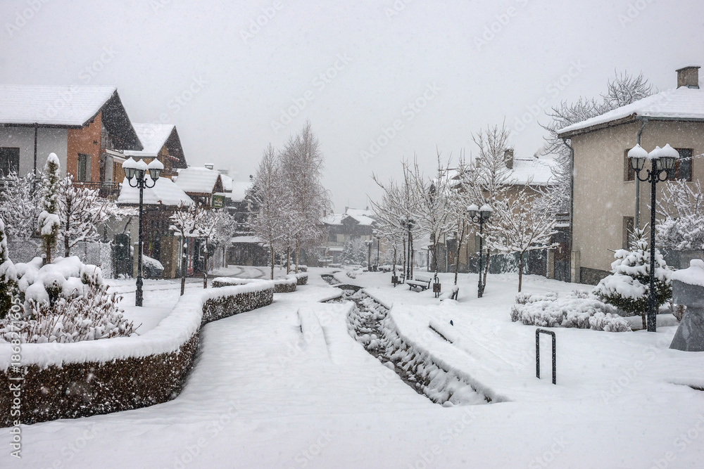 Fototapeta premium Small bulgarian town in the winter snowy day. Gotse Delchev street, a kempt pedestrian street in city center.