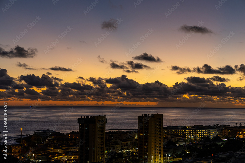 Fototapeta premium Sunset over the Atlantic Ocean and the town of Las Americas, Tenerife, Canary Islands.