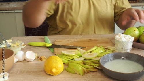 A man slices apples to prepare a traditional dessert.