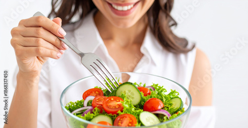 Close up de una mujer feliz comiendo ensalada fresca con tomate y lechuga, concepto de alimentación saludable, dieta equilibrada, hábitos de vida sana y control de peso, en fondo blanco