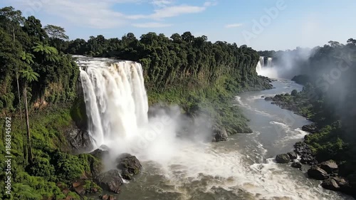 Majestic waterfalls cascading through lush green landscape under blue sky