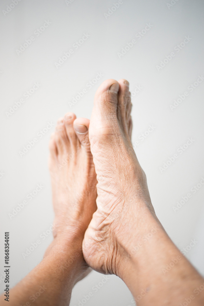 Fototapeta premium Close-up of senior man foot on white background with copy space