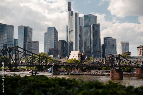 Frankfurt skyline with historic bridge and modern skyscrapers on a cloudy day