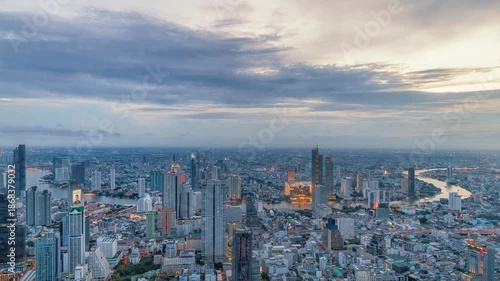 Night timelapse of Chao Phraya River, Bangkok with busy ferries and vibrant city skyline.