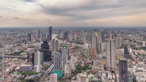 Night timelapse of Chao Phraya River, Bangkok with busy ferries and vibrant city skyline.