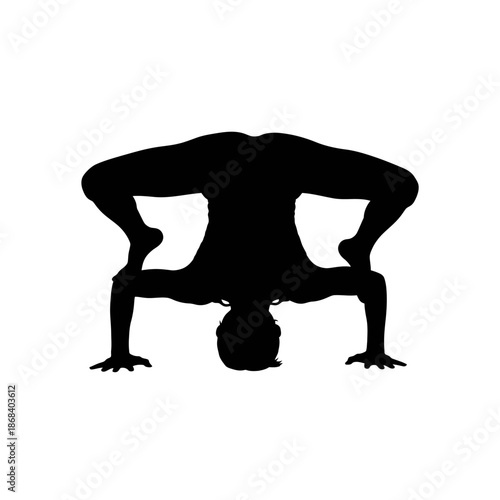 Silhouette of a person performing yoga headstand pose.