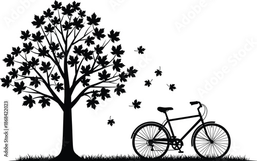 Black silhouette of a bicycle under a tree with falling maple leaves and grass falling leaves