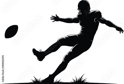 Black silhouette of American football player kicking ball on grass
