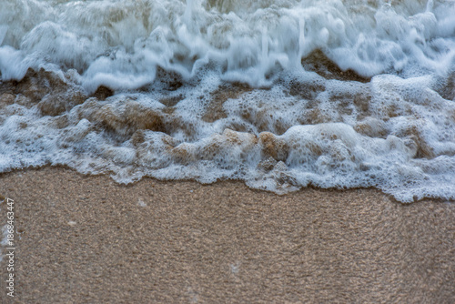 Waves Crashing on Sandy Beach Shore.