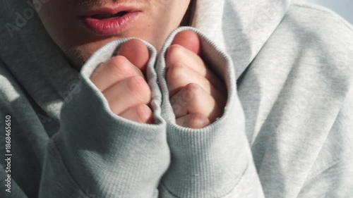 A freezing man in a long-sleeved sweater.
A warmly dressed man warms himself in low temperatures.