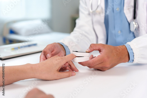 Doctor examining patient's oxygen levels and pulse rate using a pulse oximeter in a clinic, providing healthcare