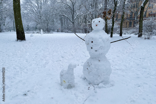 Classic Snowman and Snowdog in Berlin Kreuzberg on a snowy winter day at Grimmstrasse park. 