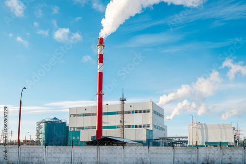 white smoke from a red chimney against a blue sky