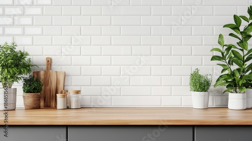 The built-in kitchen cabinet set in modern grey displays an assortment of household products on a blank and empty countertop, set against white ceramic wall tiles