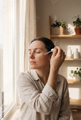 Morning skincare routine applying facial serum with natural light