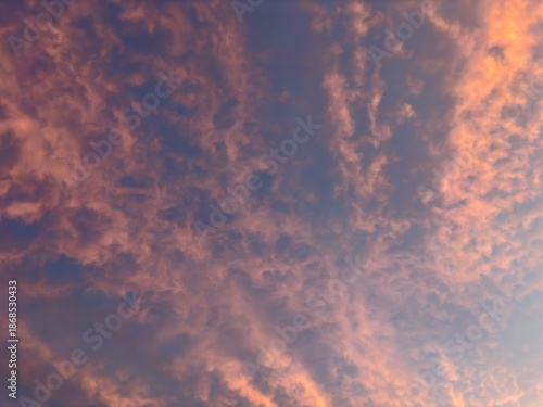Pink clouds in the evening sky during sunset with soft pastel colors. Natural sky background suitable for wallpapers, nature designs, inspirational visuals, and creative projects.