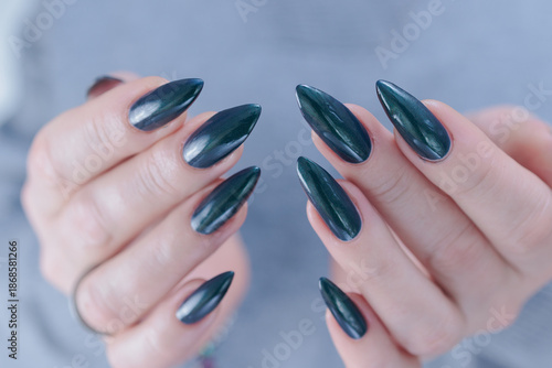 Woman's beautiful hand with long nails and blue and green nail polish