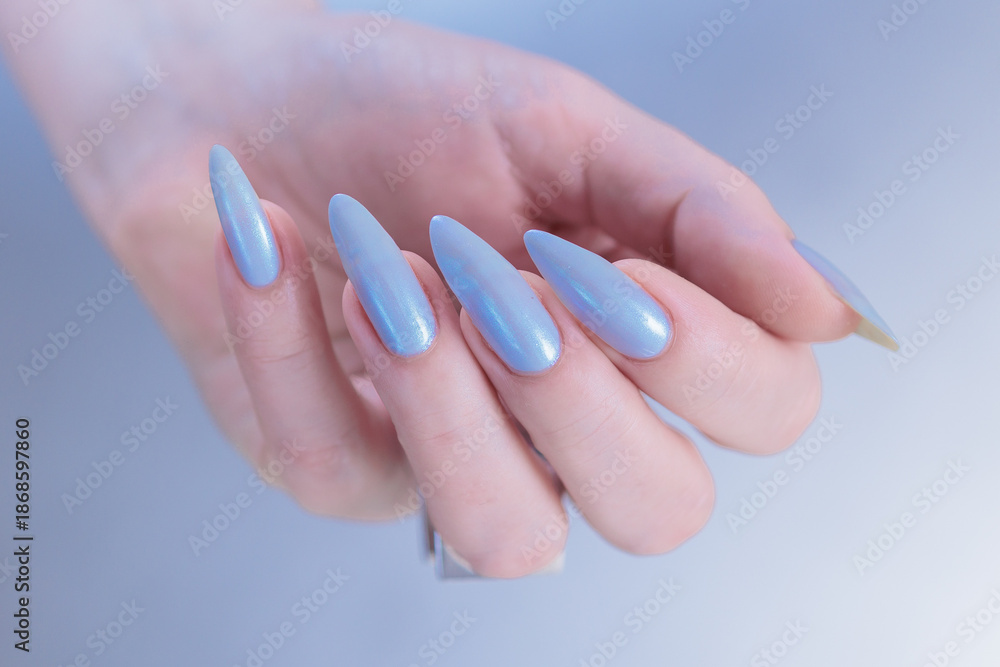 Fototapeta premium Woman's beautiful hand with long nails and light baby blue manicure