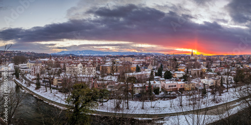 A winter panorama of the town of Český Těšín and the Beskid Mountains, visible from Cieszyn Castle Hill. A beautiful sunset. The Olza River in the foreground. The border of the two countries. Poland