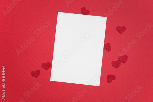 Obraz na płótnie Blank greeting card mockup on vibrant red background with scattered red heart sh