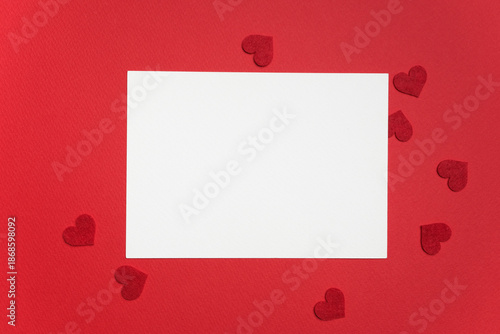 Valokuva Blank greeting card mockup on red background surrounded by small red heart shape