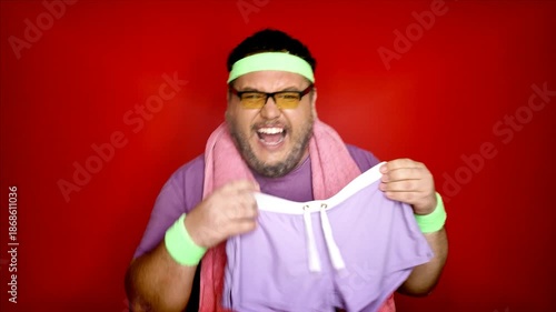 Fitness and healthy lifestyle. Overweight man on an apple diet. Red background.