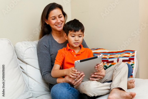 Philadelphia, Pennsylvania, USA. Native American mother and young  son reviewing homework on computer tablet