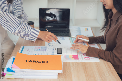 Obraz na plátne Setting Target in the Workplace: Two businesswomen intently focused in collaborative workplace environment, the image encapsulates focus and dedication in achieving targets